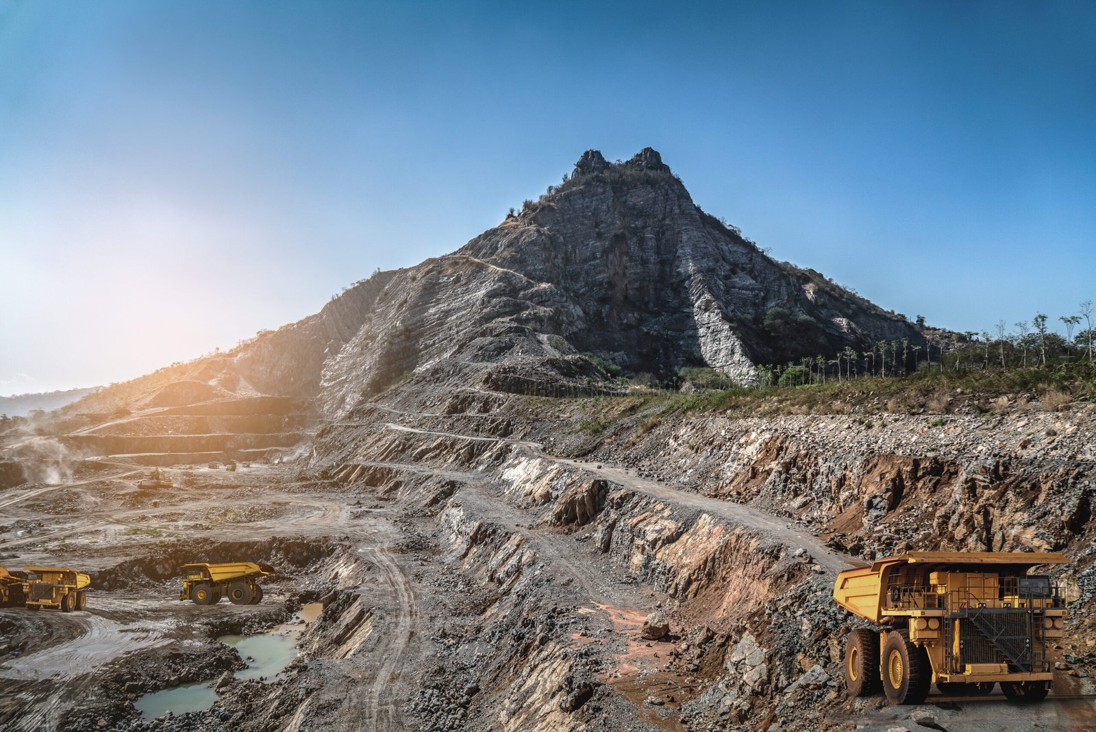 yellow dump truck loading minerals copper, silver, gold, and other at mining quarry.